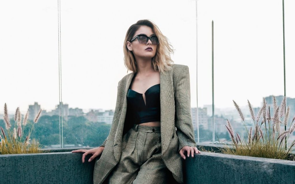 woman wearing sunglasses in a tailored blazer plaid two piece suit with bustier